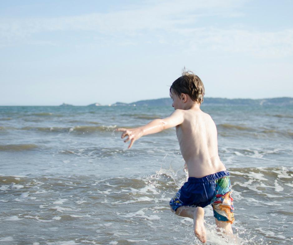 Boy running into the sea