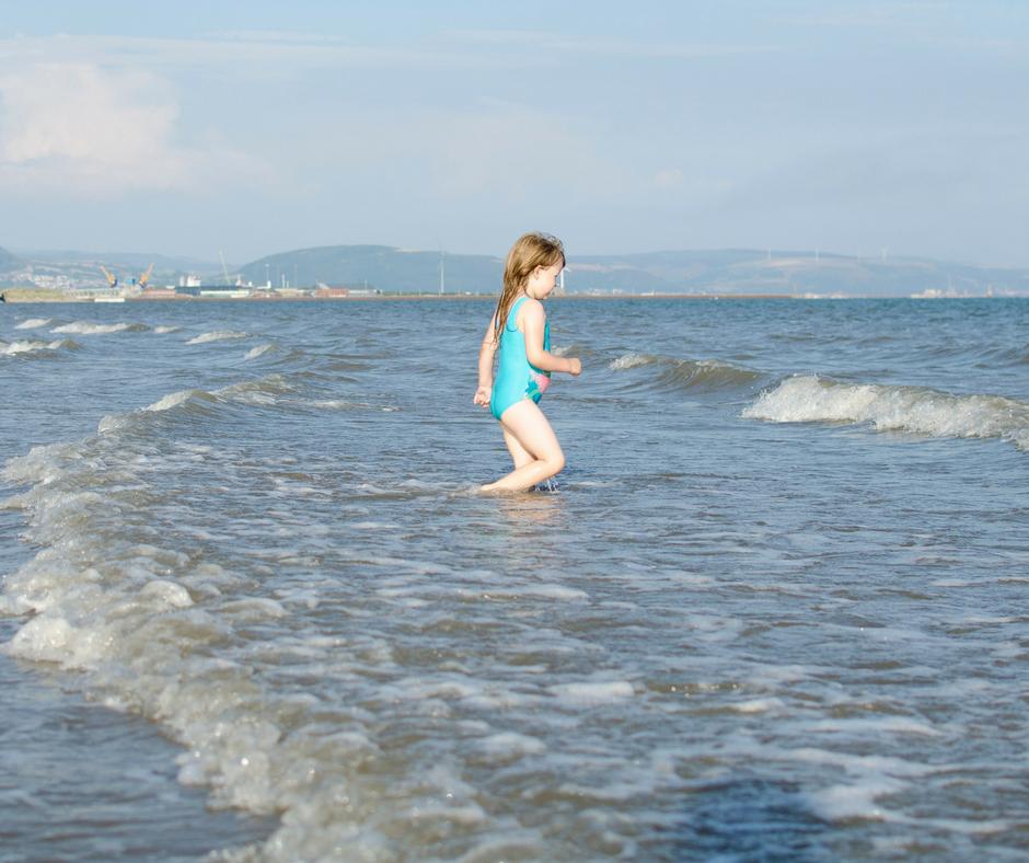 Young girl running into the sea