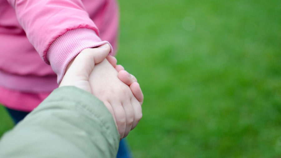 Mother holding child's hand